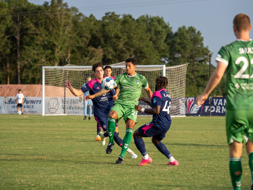 Forward, Leo Castro juggles the ball between two players in 2-1 win over Tormenta.