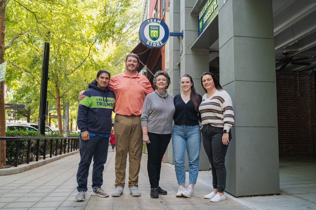 (left to right) Gio Canas, Jake Tomlinson, Stacy Wise, Christian Brookshire, and Kylie Nelson as pose in front of the Triumph Store.