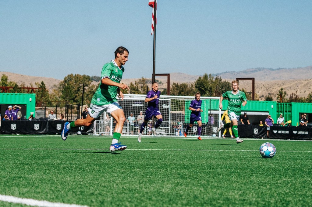 Greenville Triumph players in green running onto a loose ball at Athletic Club Boise